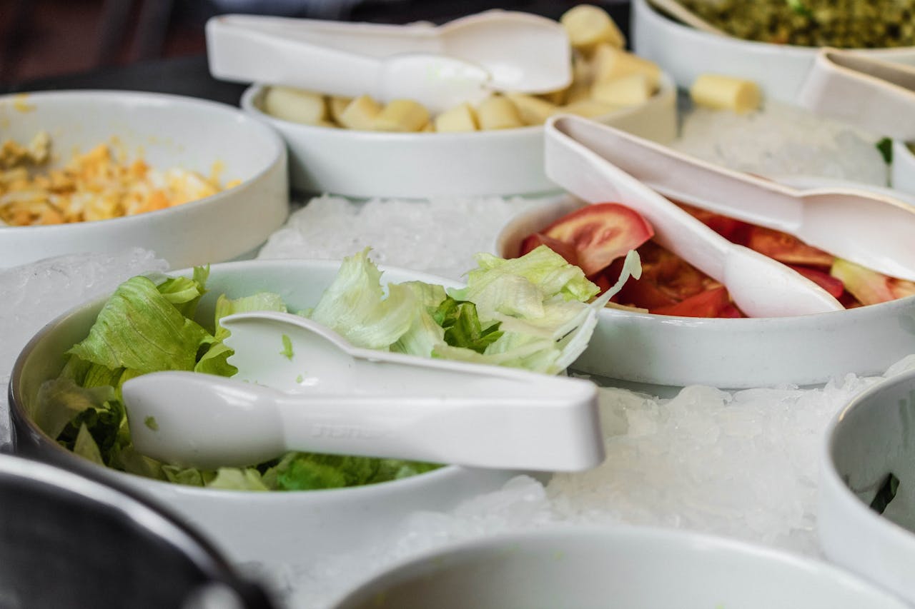 Close-up view of fresh vegetable salad bowls with ice at a buffet restaurant.