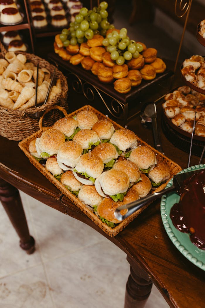 A delicious buffet spread featuring small sandwiches, pastries, and fresh fruits, perfect for a party or celebration.